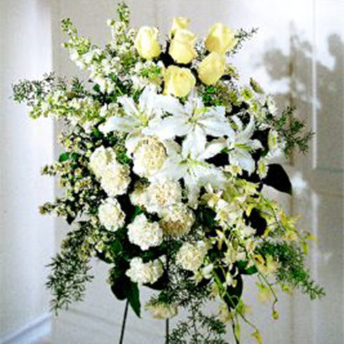 A Quiet Tribute in a monochromatic color scheme of White and Off-White Spray Roses, Lilies, Carnations and Dendrobium Orchids.     FTD 3156