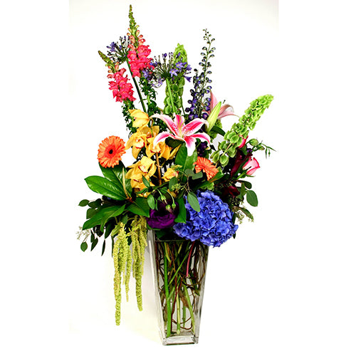 In remembrance of that special person. This mixed arrangement of lush garden flowers and cymbidium orchid spray is abundant in beauty and love.  Approximate Height 50” by Width 27”